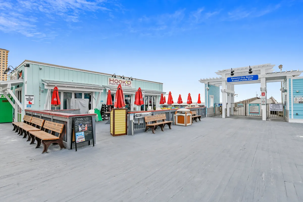 An exterior shot of a vibrant restaurant structure with outdoor seating and a welcoming entrance archway. The open-air setting encourages socializing, late-night dining, and people-watching—capturing the local dining and nightlife scene steps from the resort.