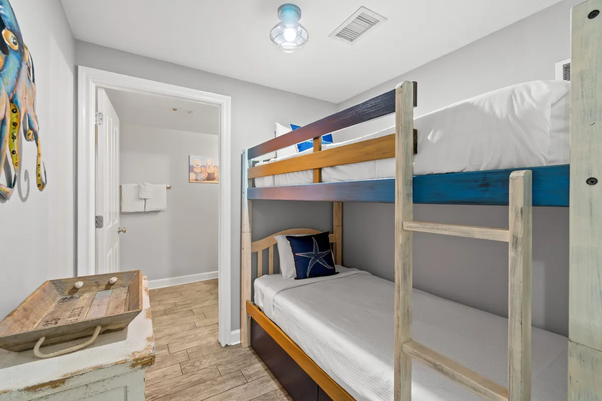 A charming children’s bunk area with a playful bunk bed, colorful wall art, and a small wooden tray. The space feels cheerful and welcoming, perfect for young guests to play, read, or drift off to sleep after a day of adventure.